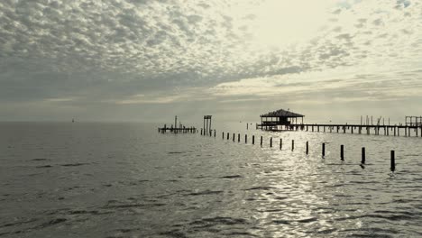 Aerial-view-of-birds-on-an-old-dock-and-in-flight-on-Mobile-Bay,-Alabama