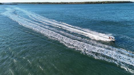 aerial view of jet skis racing across clear waters at gold coast, australia. captured in vibrant daylight with dynamic motion