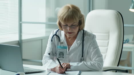 Doctora-Senior-Trabajando-En-Una-Laptop-En-El-Consultorio-Médico