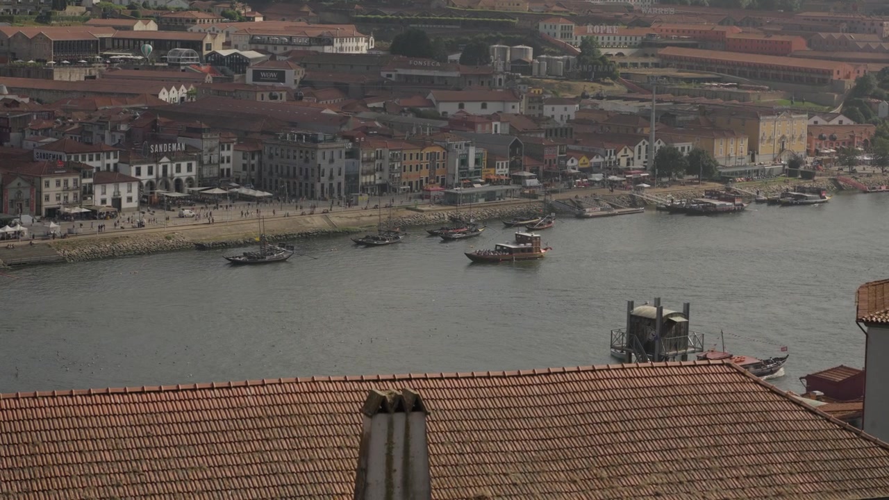 Cantine di vino Porto e barche Rabelo lungo la riva del fiume Douro a Vila Nova de Gaia.
