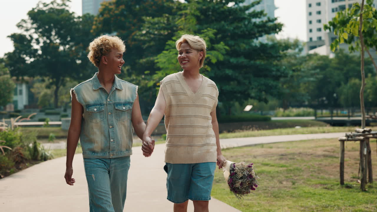 Gay couple walking in park holding hands