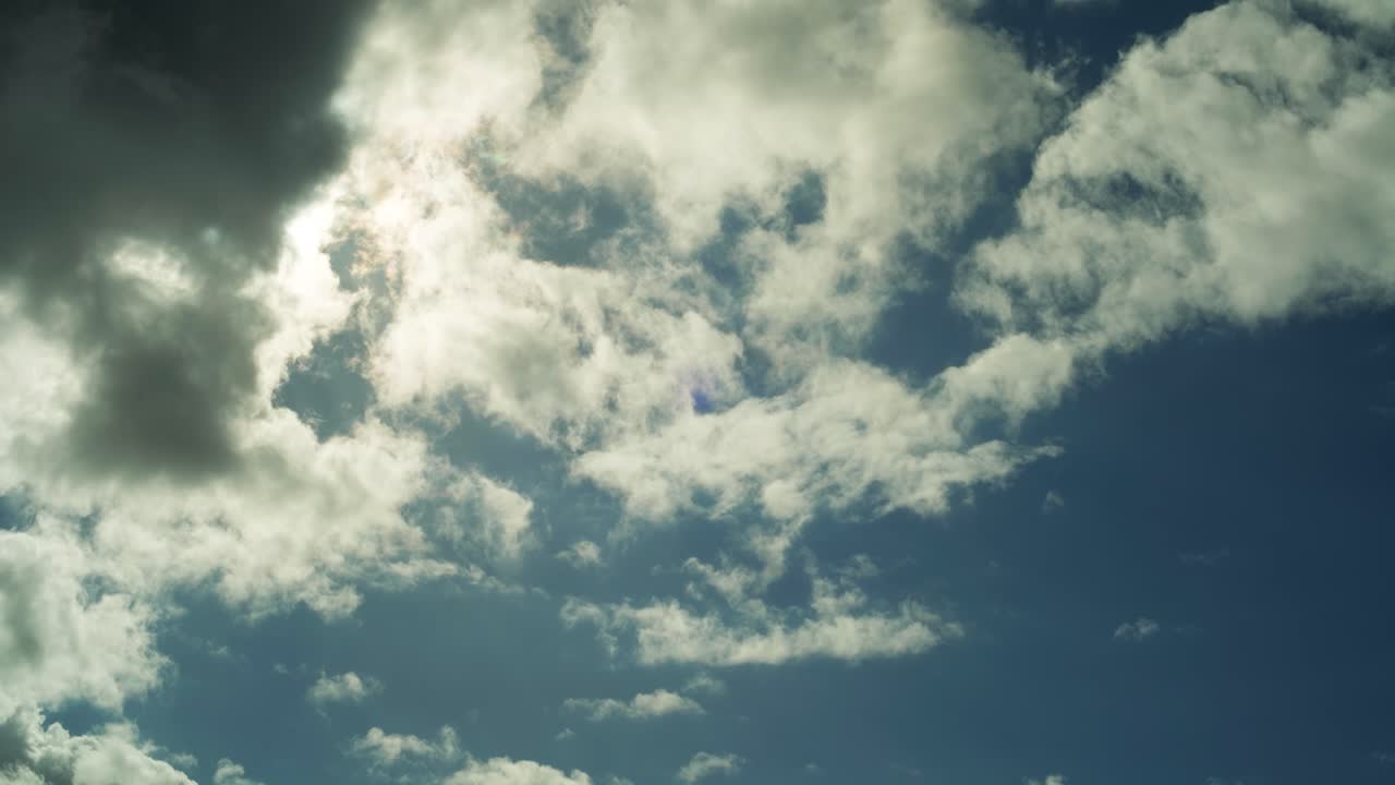 timelapse de 4k de un cielo azul soleado, con nubes pasando frente al sol