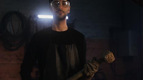 un herrero trabajando en un taller oscuro