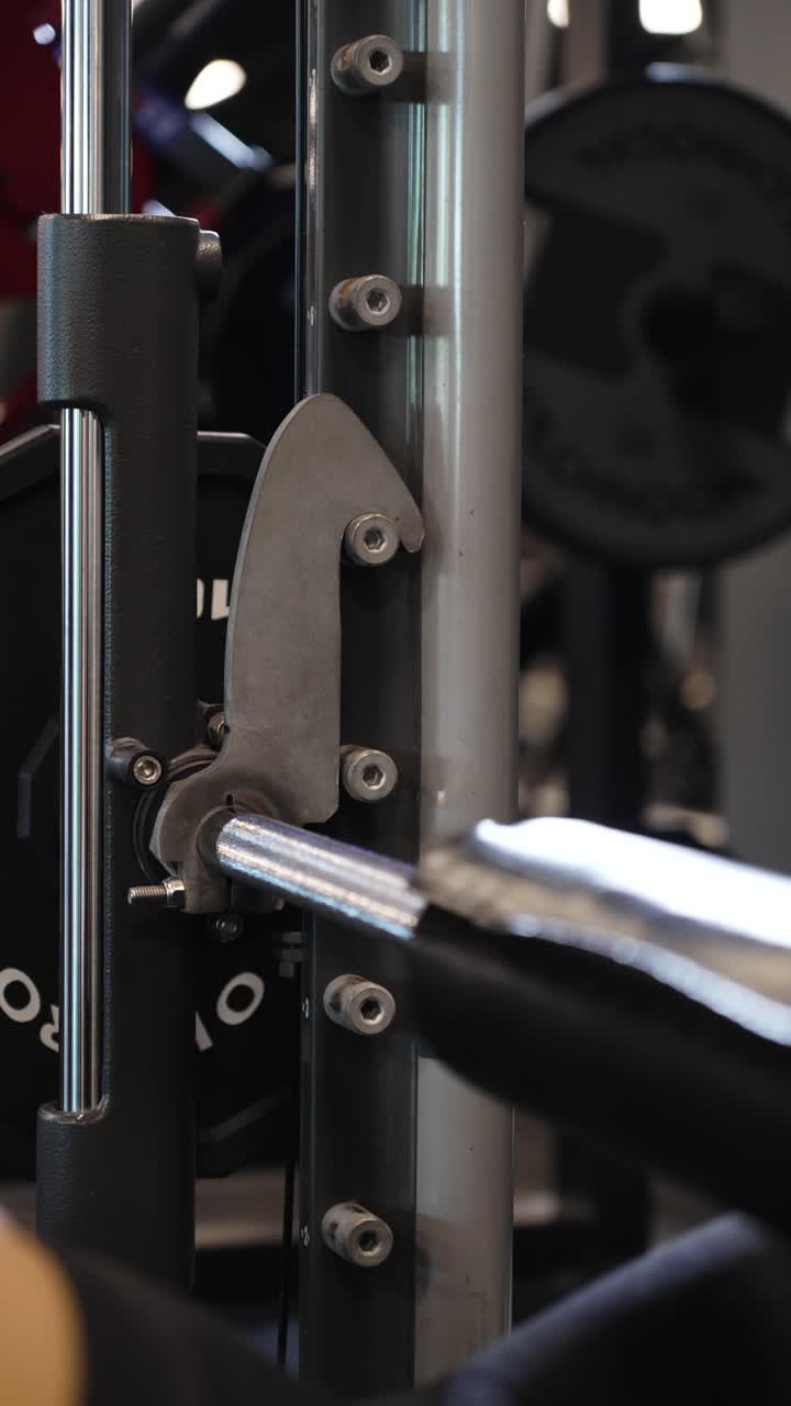 Vertical slowmotion shot of an athlete reracking the barbell after doing hip thrusts