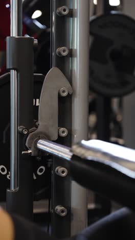 vertical slowmotion shot of an athlete reracking the barbell after doing hip thrusts