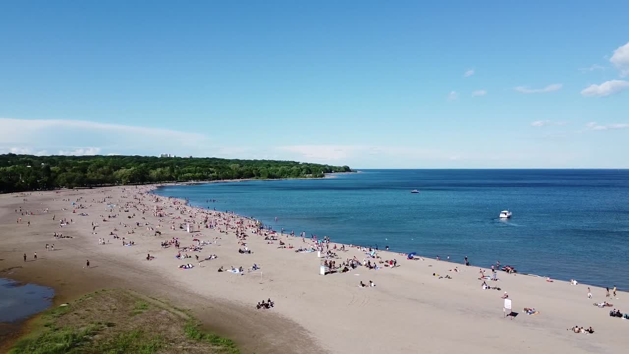 화창한 여름날 온타리오 호수에 보트가 있는 붐비는 토론토 해변의 항공 샷