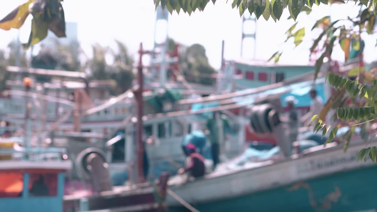 배 위에 그물과 잎을 든 아시아 어부들의 흐릿한 모습