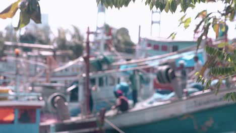 blurred-view-of-Asian-fishermen-with-nets-on-boat-and-leaves