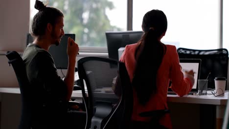 Business-colleagues-interacting-with-each-other-at-desk-in-office-4k