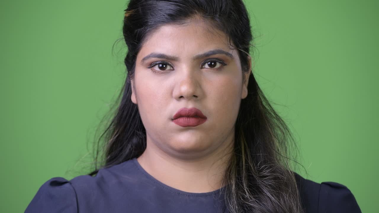 초록색 배경에 젊은 과체중 아름다운 인도 사업가