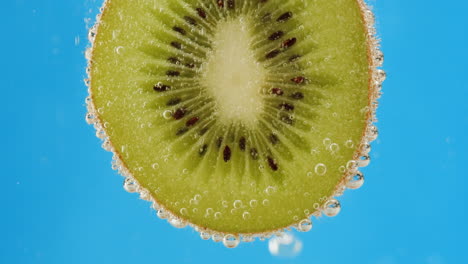 kiwi slice in water with bubbles