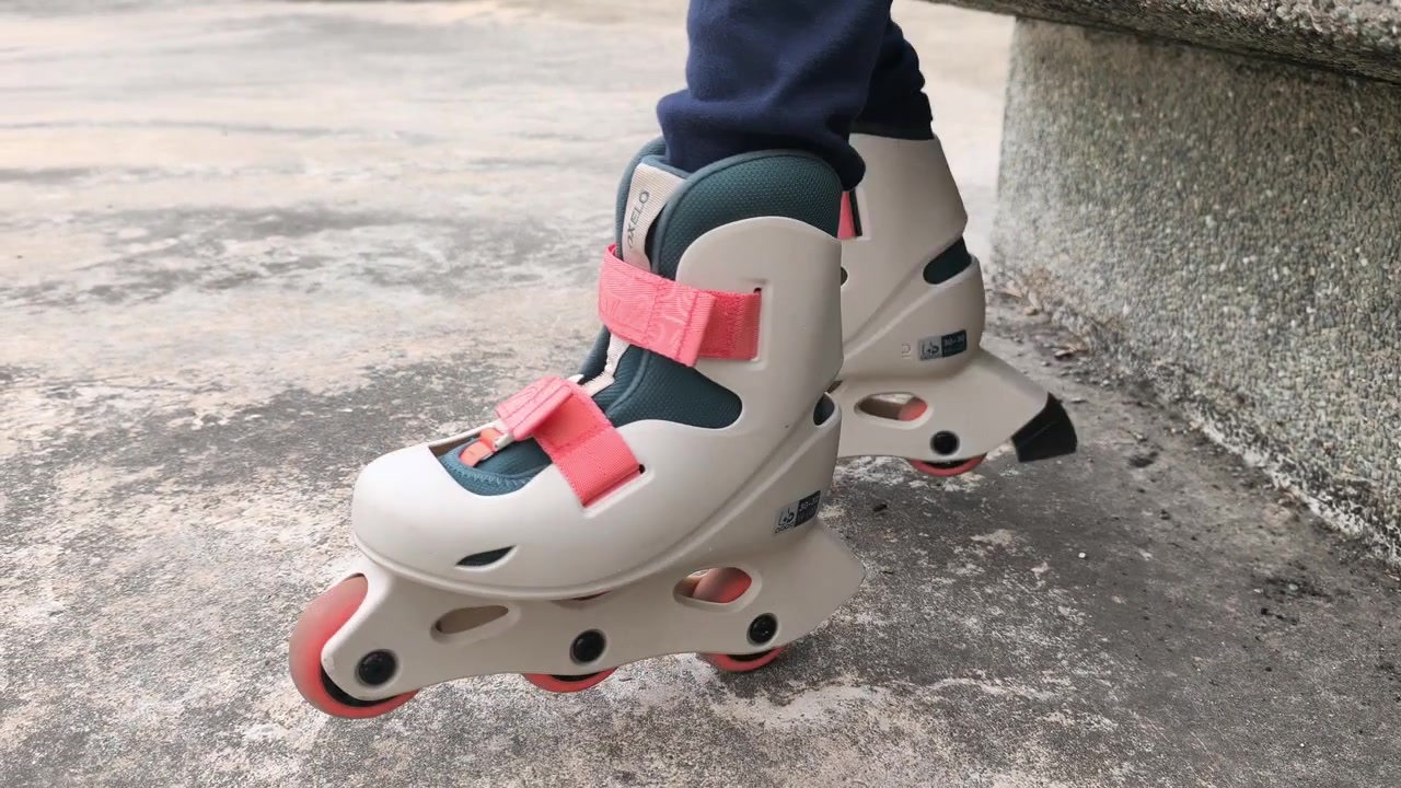 A young girl enjoys a relaxed ride on her pink rollerblades. The camera focuses closely on her feet moving slowly and freely. This peaceful moment captures a calm, leisurely activity.