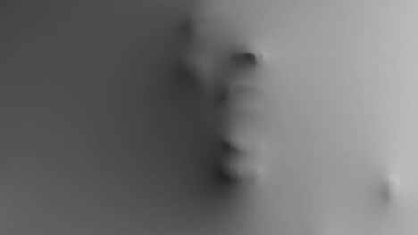 a scary face and hands appear from the white surface