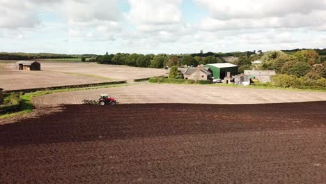 aerial footage over tractor ploughing field