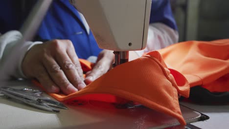 mixed race woman using sewing machine in factory