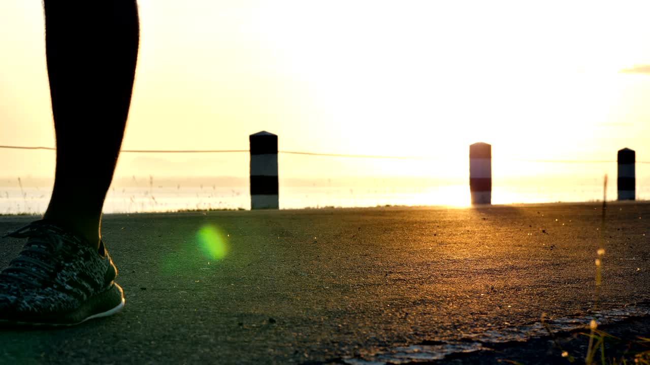 Men walking and running on the street in the nature the time during sunrise on dam road exercise. Healthy lifestyle. Slow motion