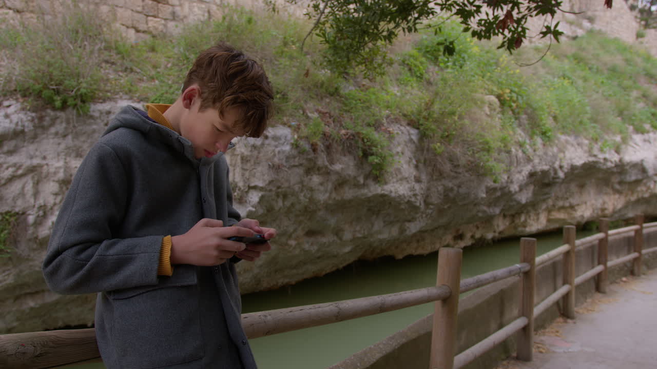 채널에 의해 스마트폰을 사용하는 십대 소년