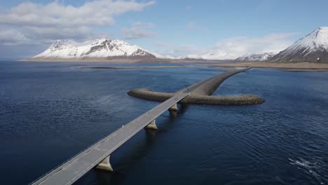 following from above a single car driving across the viking sword bridge towards the peninsula