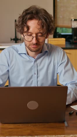 hombre trabajando en una computadora portátil y bebiendo café