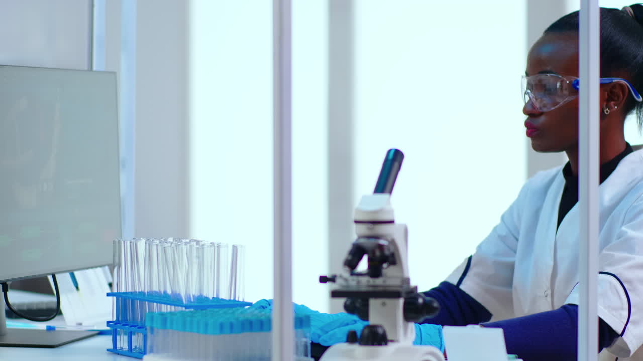 Portait of black woman chemist typing on pc checking virus development