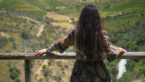 Cámara-Lenta-De-Mujer-Con-Vestido-Azul-Y-Dorado-Disfrutando-De-La-Naturaleza-En-Pasamanos-De-Madera