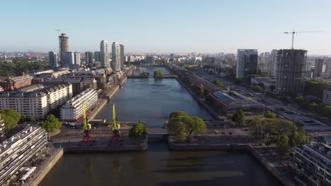 Aerial-forward-flight-over-Puerto-Madero-with-cars-crossing-bridge-in-Buenos-Aires-at-sunset