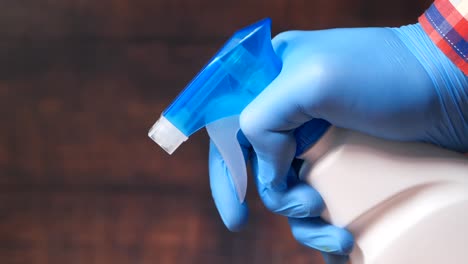 person cleaning with spray bottle and gloves