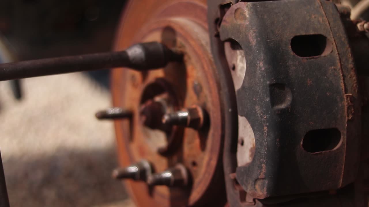 Close up of cross wrench being used to loosen a lug nut of a car wheel rotor
