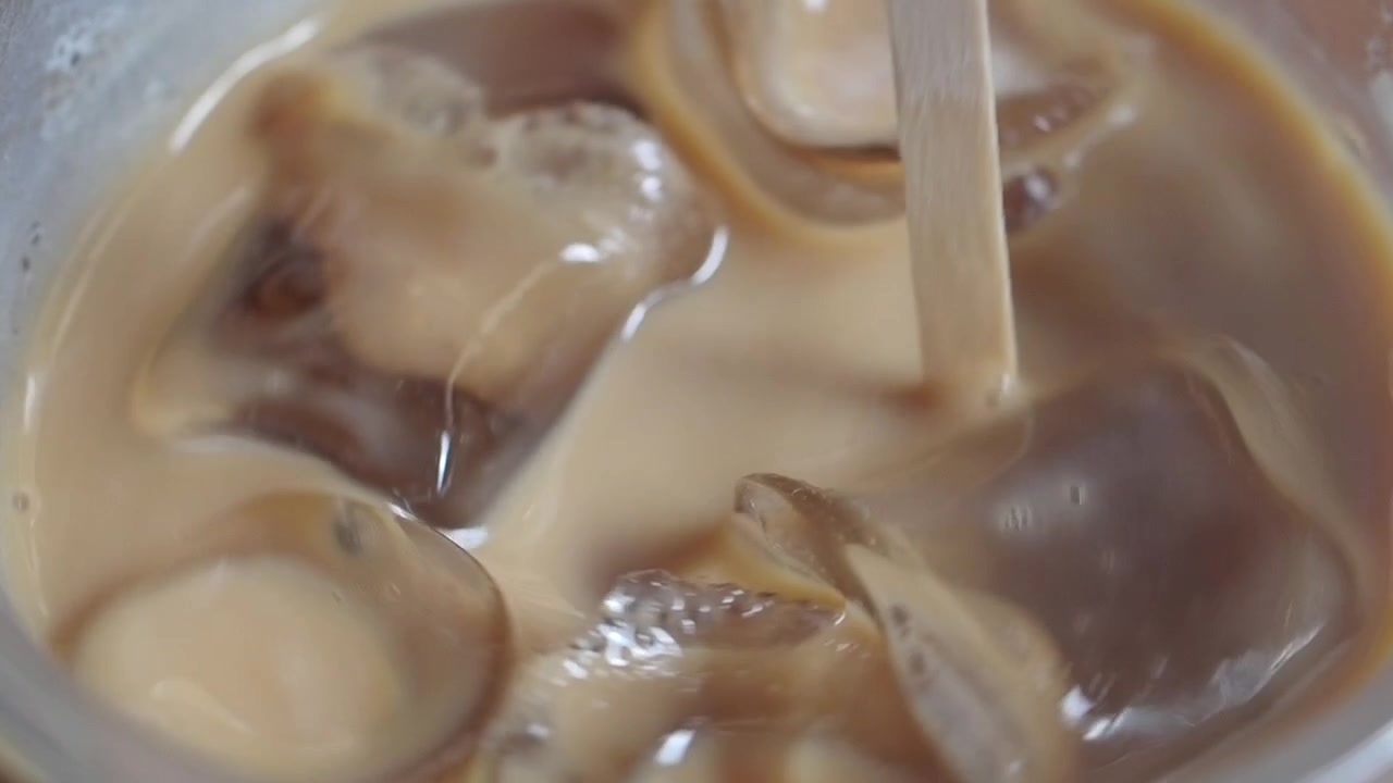 Caffè freddo rinfrescante con cubetti di ghiaccio mescolati