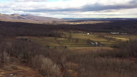 Drone-Se-Eleva-Sobre-El-Hermoso-Valle-De-Pintorescas-Granjas-En-La-Región-Montañosa-De-Catskill,-Con-Maravillosas-Sombras-De-Nubes