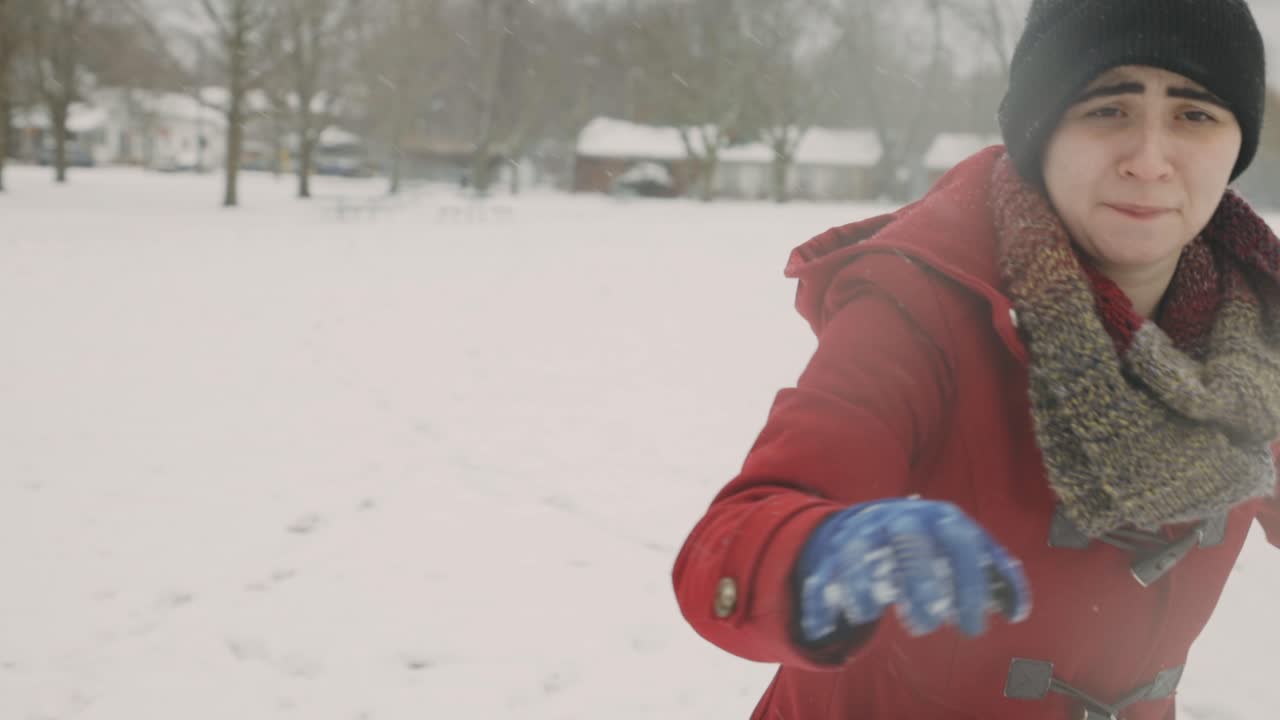 Donna che lancia una palla di neve verso la telecamera - Inquadratura media a mano libera