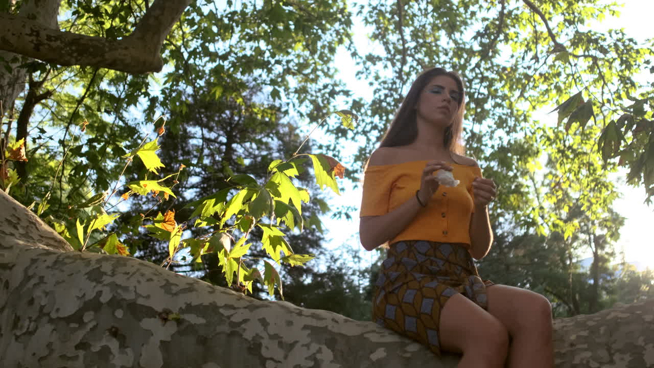 나무 가지 에 앉아 리 에 머리 를 고 있는 어린 소녀 모델