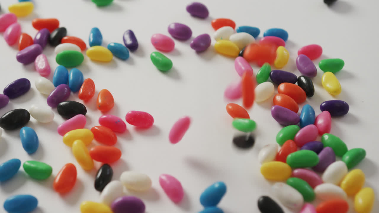 video de primer plano de dulces multicolores cayendo sobre un fondo blanco
