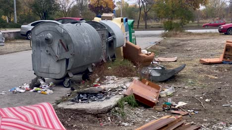 overfilled garbage bin and plastic rubbish bags causing environmental problem, static shot, sofa, armchair at background