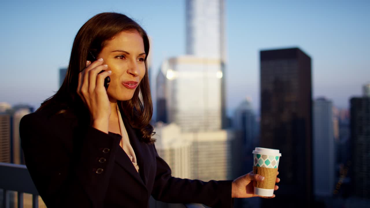 해가 뜨는 지붕에서 스마트폰을 사용하는 히스패닉 여성 매니저