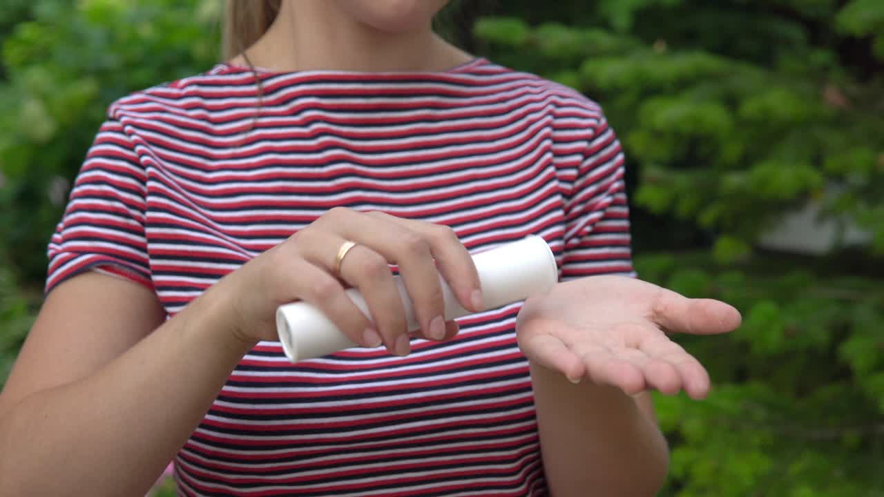 The girl holds a capsule in her hand and takes out vitamins from it into the palm of her hand. Maintaining immunity. Healthy lifestyle.