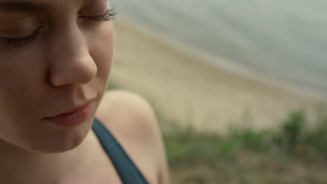 Closeup-girl-face-meditating-on-beach.-Portrait-of-focused-woman-doing-yoga