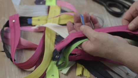 seamstress sorting through a pile of zips