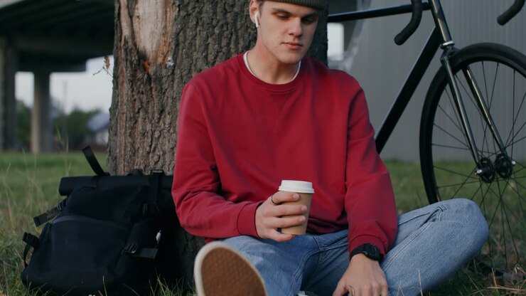 Giovane uomo in pausa caffè nel parco