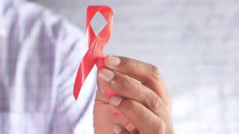 person holding a red ribbon for aids/hiv awareness