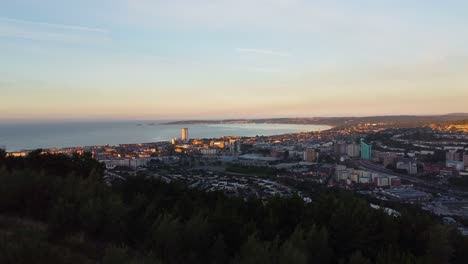 city at dawn showing buildings and ocean bay - aerial drone footage