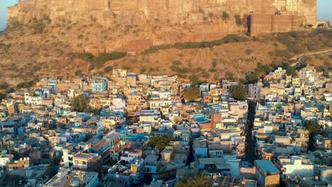 Sunrise-fly-over-of-densely-populated,-Blue-city-of-Jodhpur,-Rajasthan,-India