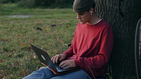 adolescente trabajando en una computadora portátil en un parque