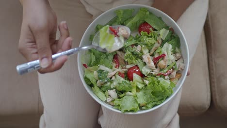 mujer comiendo una ensalada de pollo saludable