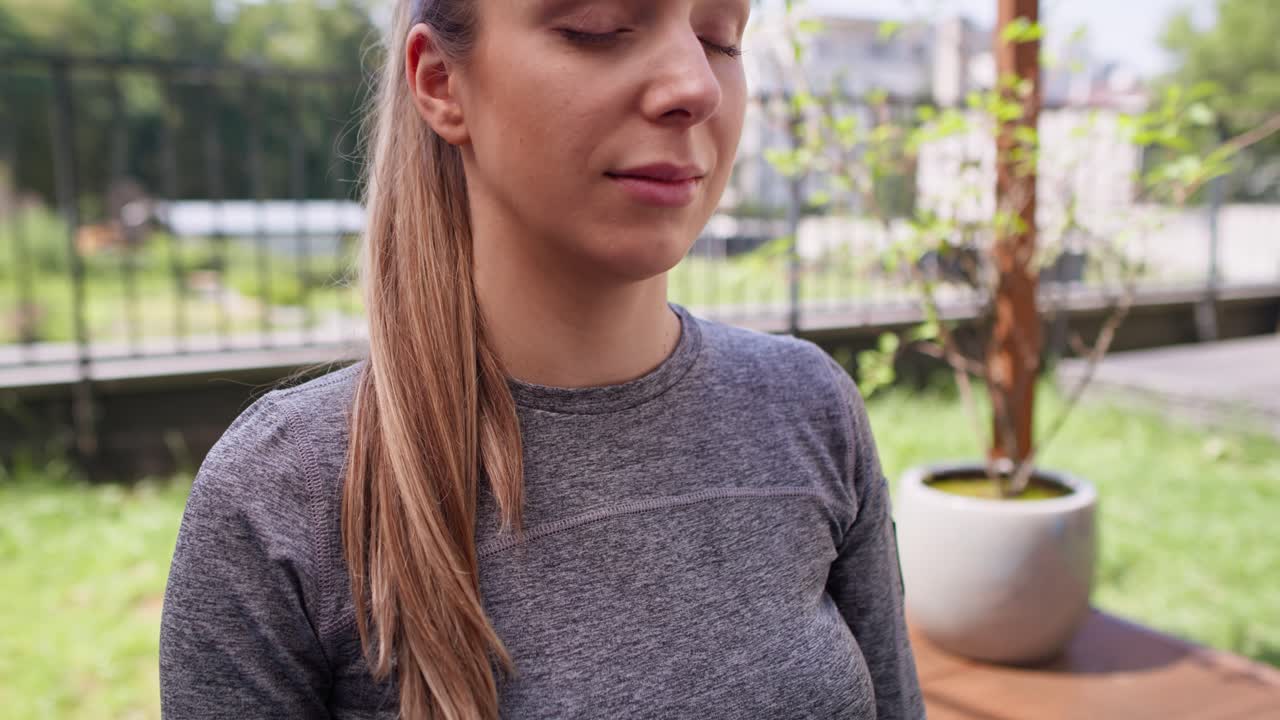 Těhotná žena medituje na zahradě