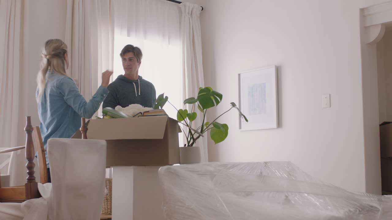 행복한 가족이 새로운 집으로 이사합니다. 주인들은 사진을 걸고 아이들과 함께 집을 꾸미고 있습니다. 젊은 부부는 아이들과 함께 부동산 투자를 즐기고 있습니다. 4k 영상