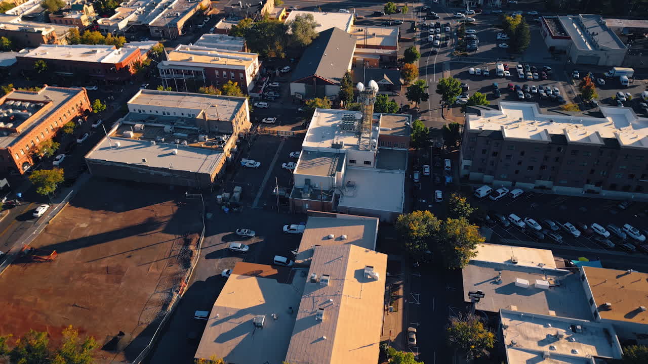 Flying over the low-rise urban landscape of Nativity in Flagstaff, Arizona, USA. Lots of cars are parked or move by the city