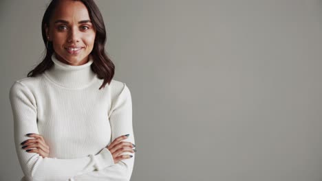 professional businesswoman standing confidently with crossed arms during studio portrait session, embodying leadership and success in sleek business attire against minimalist white background