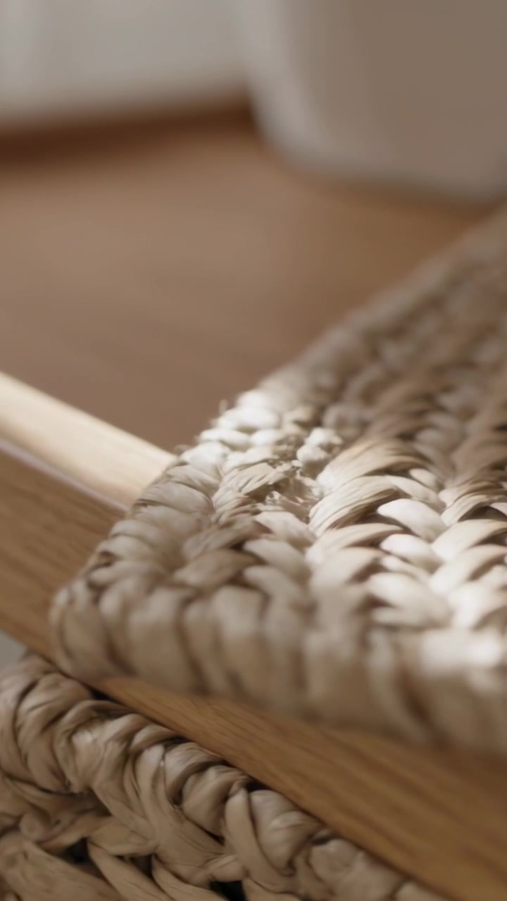 Vertical video: Starting camera pulling revealing woven seat on wood frame at home, showing texture