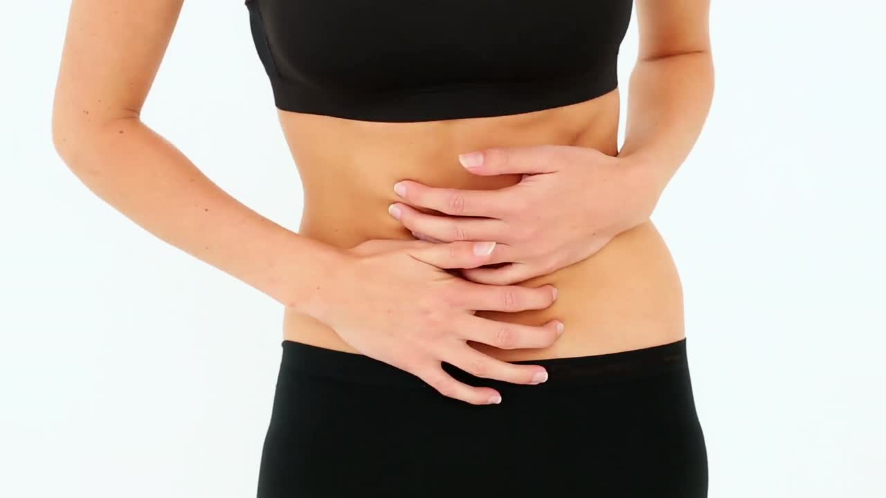 Model in sports bra touching her stomach